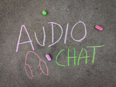 The inscription text on the grey board, Audio chat with hand drawn head phone. Using color chalk pieces.の写真素材