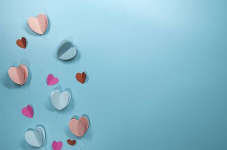 Paper elements in shape of heart flying on pastel blue background, Valentine's Day and lovey concept, copy space for note and textureの写真素材