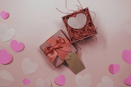Paper elements in shape of heart and gift box on pastel pink background, Valentine's Day and lovely concept, paper card for note and textureの写真素材