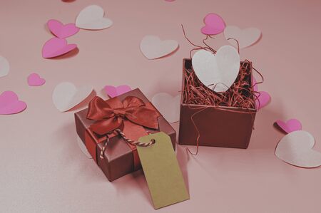 Paper elements in shape of heart and gift box on pastel pink background, Valentine's Day and lovely concept, paper card for note and textureの写真素材