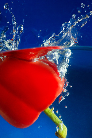 colorful sweet pepper drops in waterの写真素材