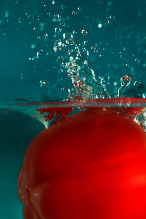 colorful sweet pepper drops in waterの写真素材