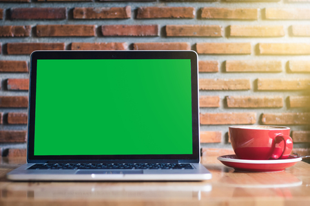 Mock-up Green Laptop Screen Monitor on wooden tableの写真素材