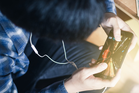young man playing games on smart phoneの写真素材