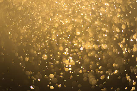 abstract gold background with soft blur bokeh light effectの写真素材