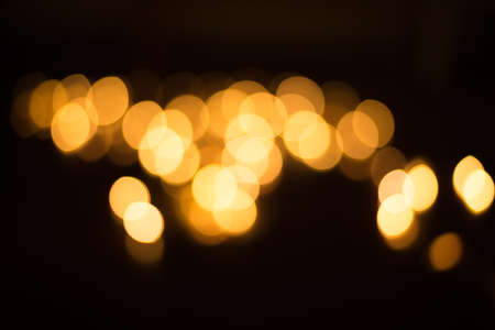 abstract gold bokeh light effect with dark backgroundの写真素材