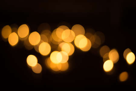 abstract gold bokeh light effect with dark backgroundの写真素材