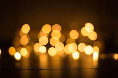 abstract gold bokeh light effect with dark backgroundの写真素材