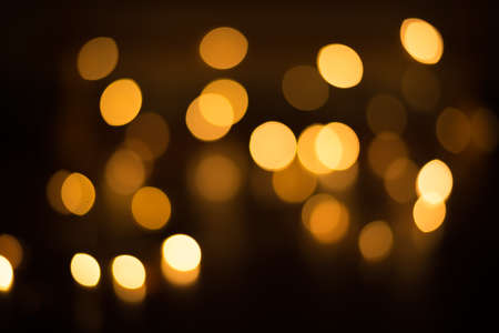 abstract gold bokeh light effect with dark backgroundの写真素材