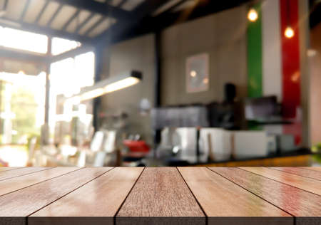 Empty wooden table top with lights bokeh on blur restaurant background.