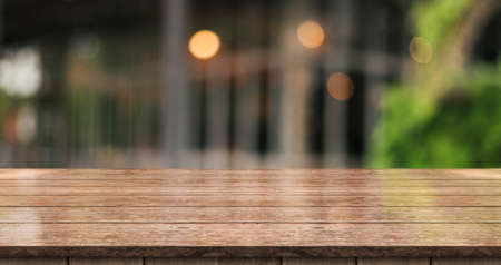 Empty wooden table top with lights bokeh on blur restaurant background.