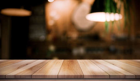 Empty wooden table top with lights bokeh on blur restaurant background.の写真素材
