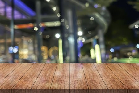 Empty wooden table top with lights bokeh on blur restaurant