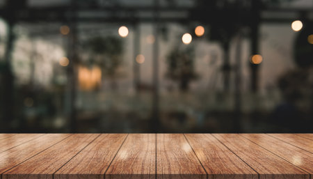Empty wooden table top with lights bokeh on blur restaurantの写真素材