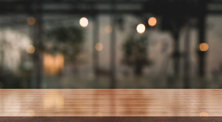 Empty wooden table top with lights bokeh on blur restaurant background.