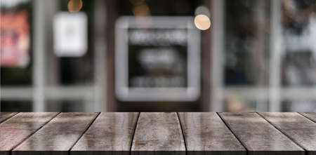 Empty wooden table top with lights bokeh on blur restaurant background.の写真素材