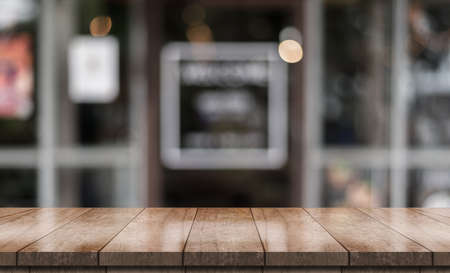Empty wooden table top with lights bokeh on blur restaurant background.