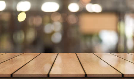 Empty wooden table top with lights bokeh on blur restaurant backgroundの写真素材