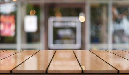 Empty wooden table top with lights bokeh on blur restaurant backgroundの写真素材