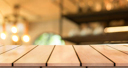 Empty wooden table top with lights bokeh on blur restaurant background.の写真素材