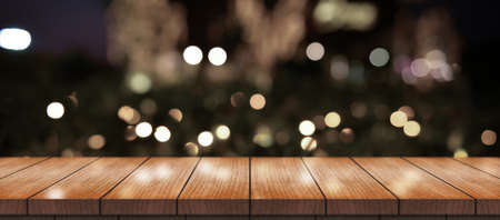 Empty wooden table top with lights bokeh on blur restaurant background.
