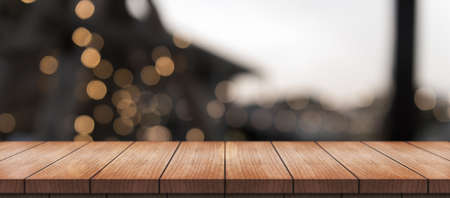 Empty wooden table top with lights bokeh on blur restaurant background.