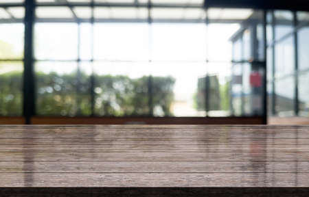 Empty wooden table top with lights bokeh on blur restaurant backgroundの写真素材