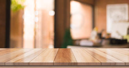 Empty wooden table top with lights bokeh on blur restaurant background.の写真素材