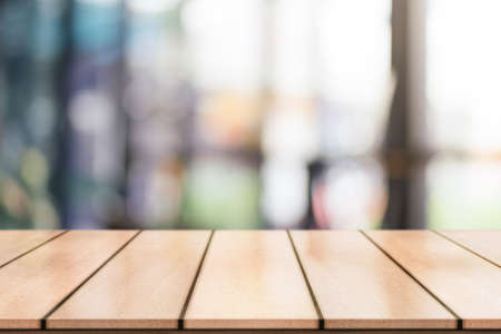 Empty wooden table top with lights bokeh on blur restaurant background.の写真素材