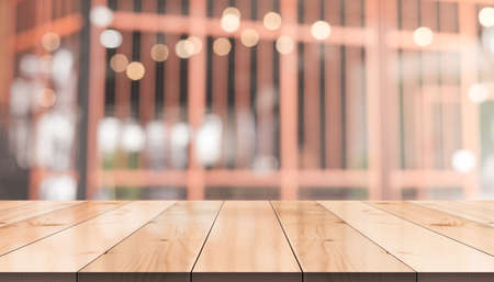 Empty wooden table top with lights bokeh on blur restaurant backgroundの写真素材