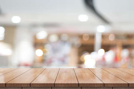 Empty wooden table top with lights bokeh on blur restaurant background.