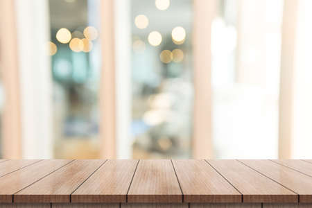 Empty wooden table top with lights bokeh on blur restaurant background.