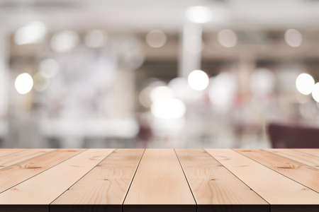 Empty wooden table top with lights bokeh on blur restaurant background.