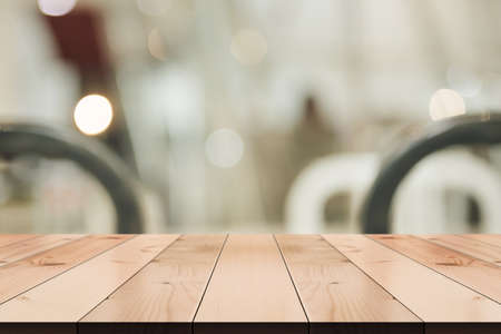 Empty wooden table top with lights bokeh on blur restaurant background.