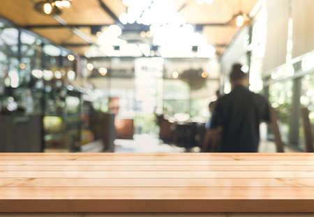 Empty wooden table top with lights bokeh on blur restaurant background.の写真素材