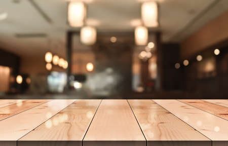 Empty wooden table top with lights bokeh on blur restaurant background.の写真素材