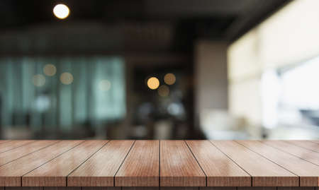 Empty wooden table top with lights bokeh on blur restaurant background.