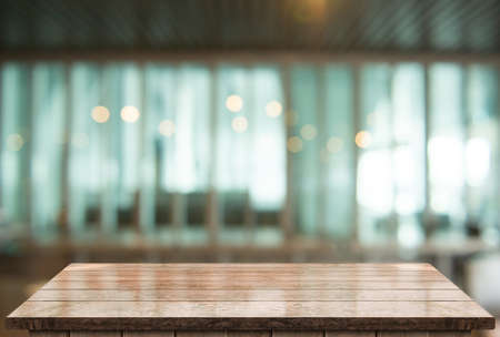 Empty wooden table top with lights bokeh on blur restaurant background.