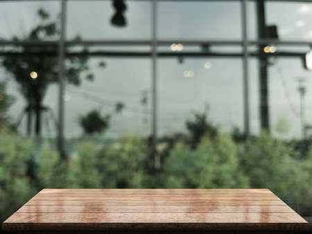 Empty wooden table top with lights bokeh on blur restaurant backgroundの写真素材