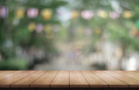 Empty wooden table top with lights bokeh on blur restaurant background.