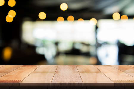 Empty wooden table top with lights bokeh on blur restaurant background.