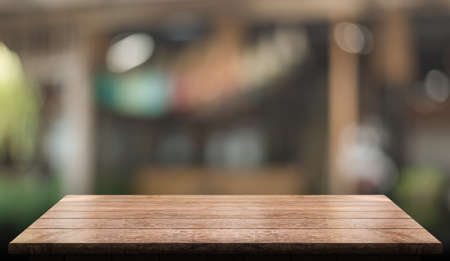 Empty wooden table top with lights bokeh on blur restaurant background.の写真素材