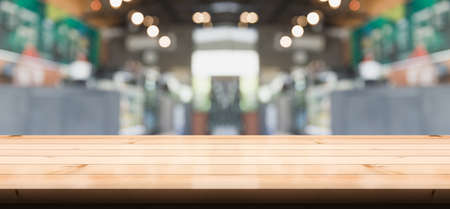 Empty wooden table top with lights bokeh on blur restaurant background.