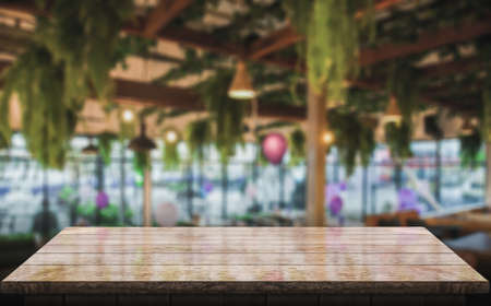 Empty wooden table top with lights bokeh on blur restaurant background.