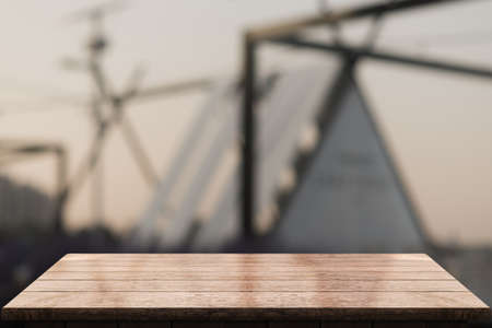 Empty wooden tabletop with lights bokeh on blur restaurant background.