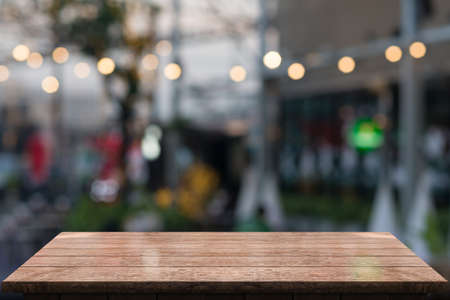 Empty wooden tabletop with lights bokeh on blur restaurant background.の写真素材