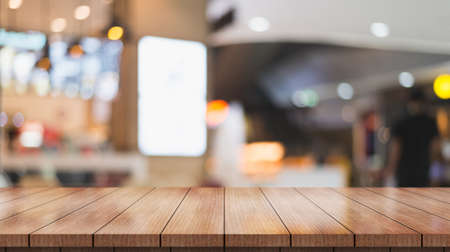 Empty wooden table top with lights bokeh on blur restaurant background.