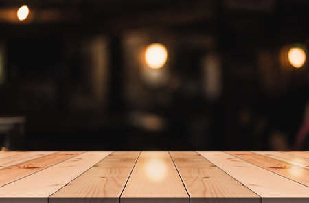 Empty wooden table top with lights bokeh on blur restaurant background.の写真素材