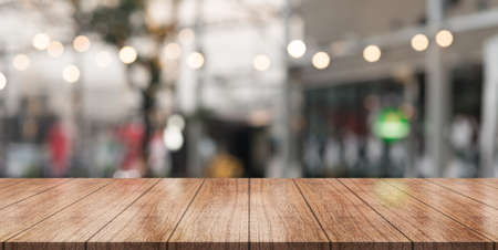 Empty wooden table top with lights bokeh on blur restaurant background.の写真素材
