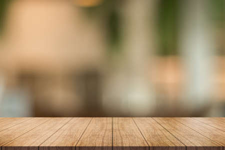 Empty wooden table top with lights bokeh on blur restaurant background.の写真素材